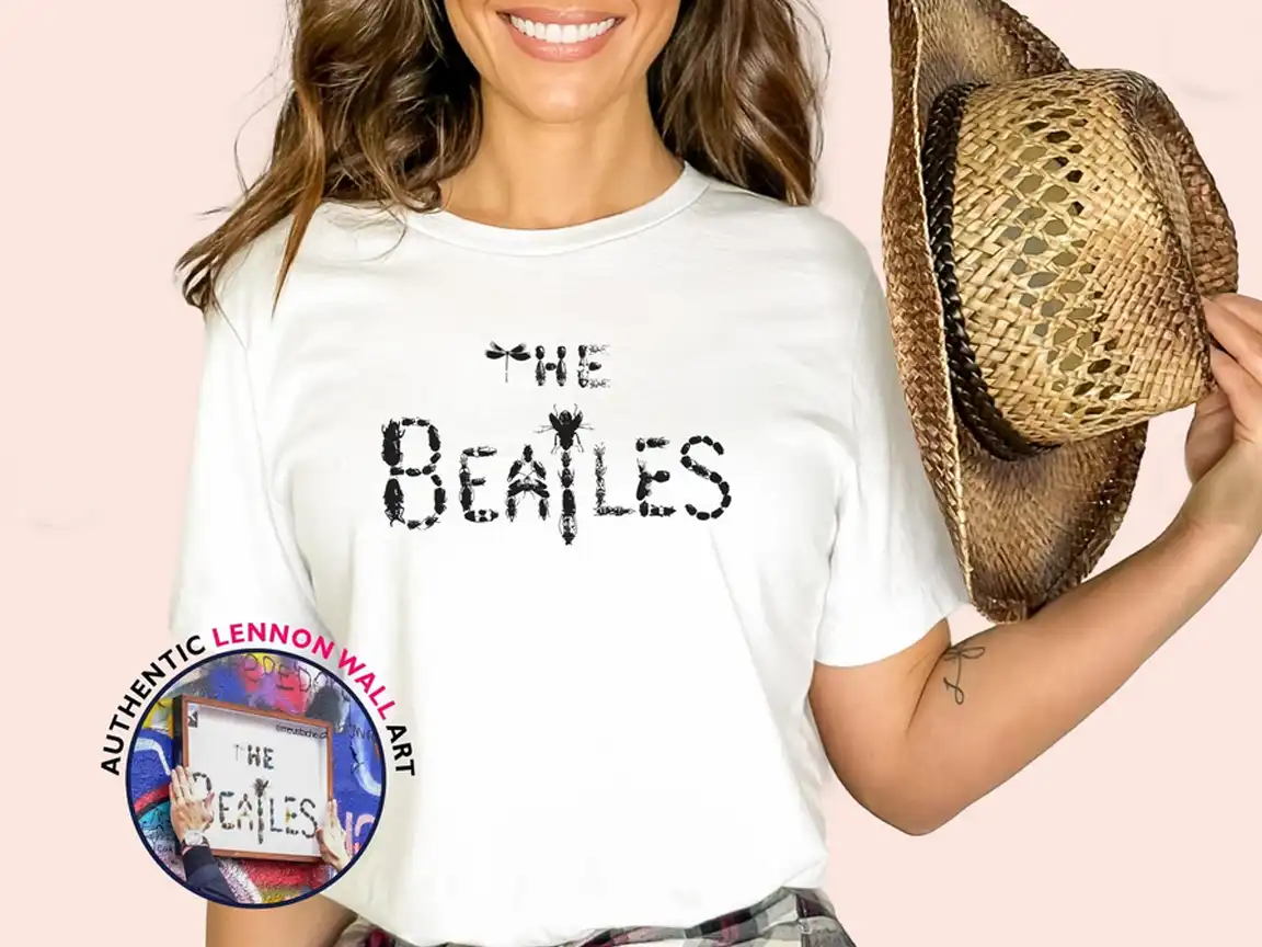 White t-shirt featuring authentic Lennon Wall street art, with The Beatles iconic logo created using beetles, designed by Czech street artist moustache, later stolen from the wall.